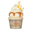 Ice cream-like product with whipped cream, caramel sauce, and straws on a white background